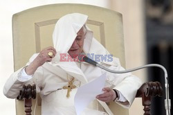 Pope mantle is blown by the wind as he reads his message during the weekly general audience